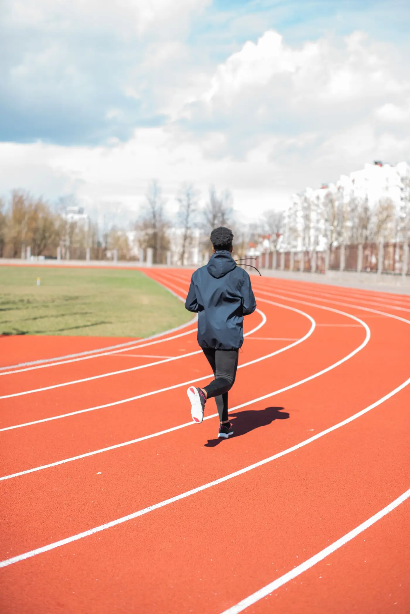 Runner training alone on the curve of an outdoor athletics track