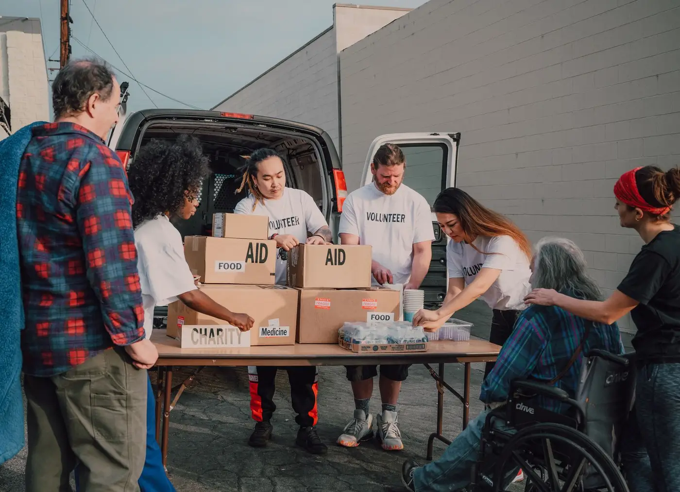 Volunteers packing boxes of food and medical aid at a charity table